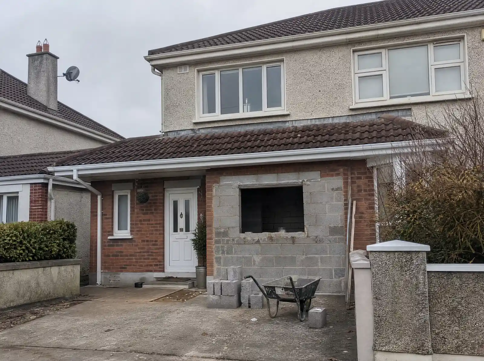 Blockwork infill wall being built across a former garage door opening on an Irish estate house