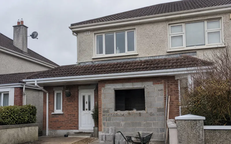 Blockwork infill wall being built across a former garage door opening on an Irish estate house