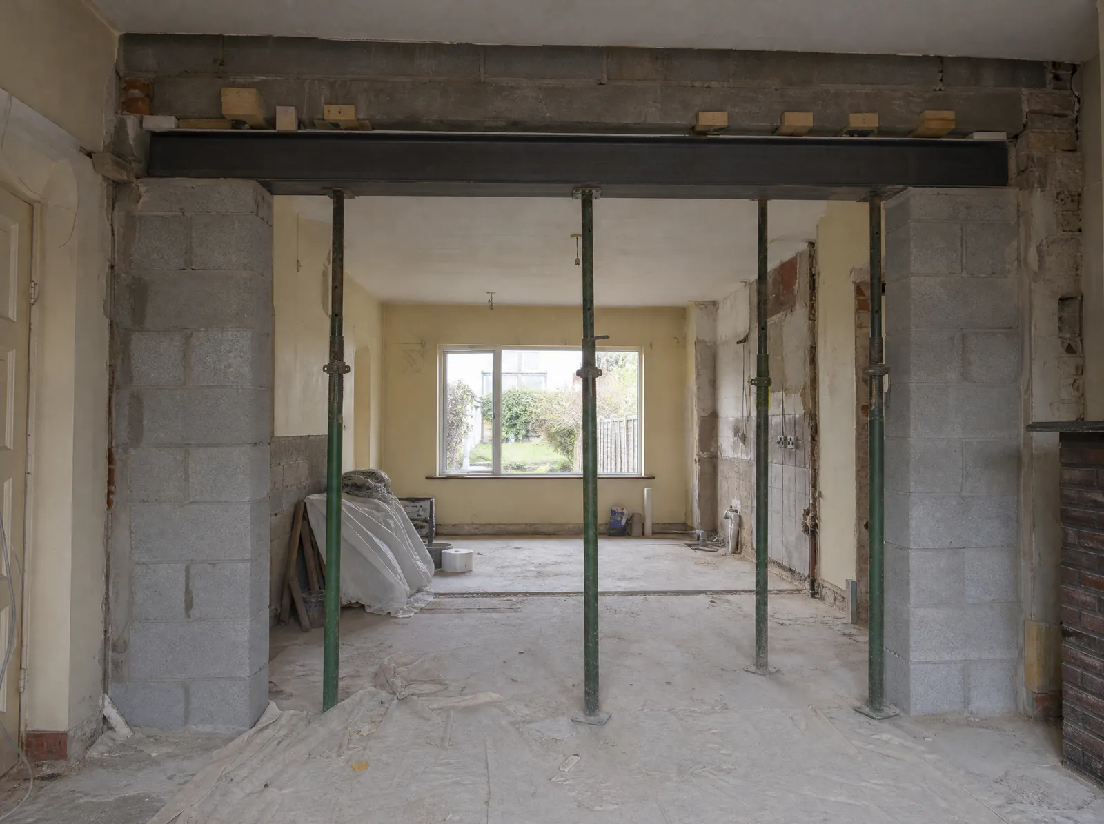New steel beam on concrete padstones across a kitchen knock-through in a Dublin semi, props still in place