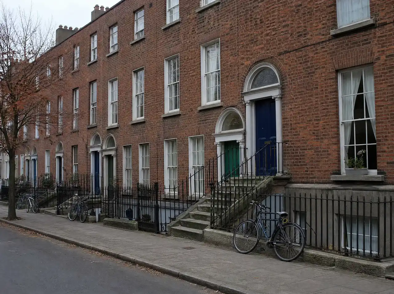 Victorian red-brick terrace over basements with cast-iron railings on a south Dublin street